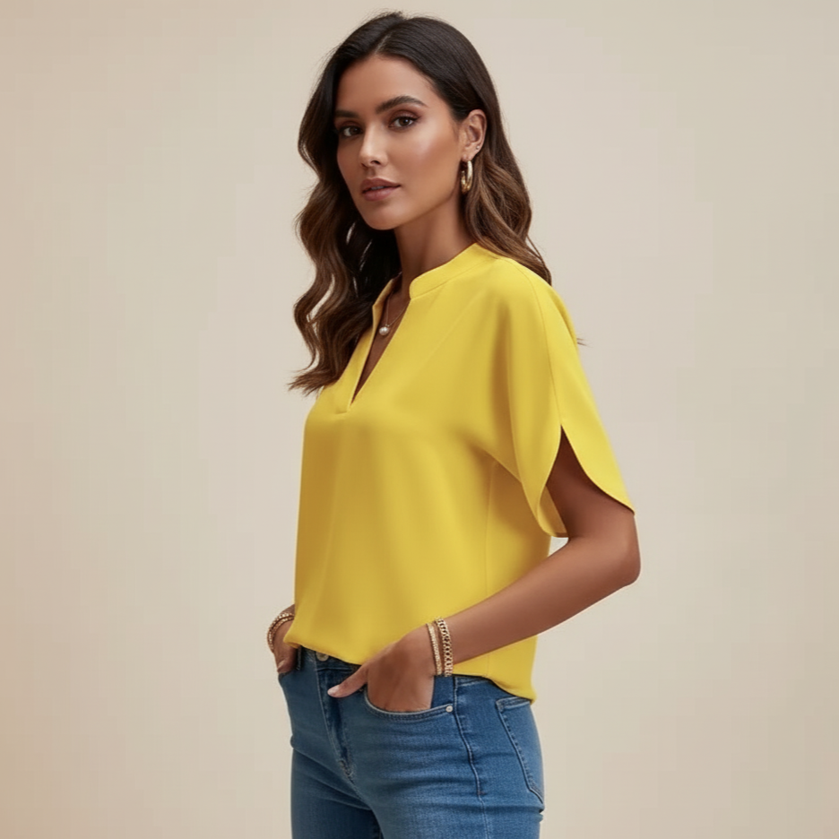 Woman wearing a yellow blouse and blue jeans against a beige background