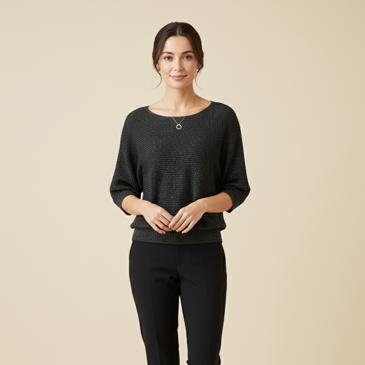 Woman wearing a black sweater and pants on a beige background