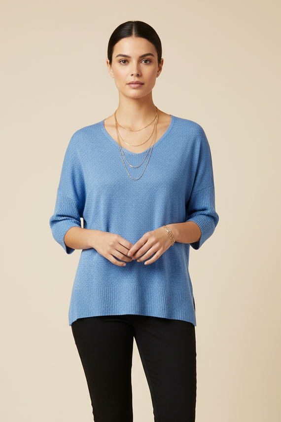 Woman wearing a blue top and black pants on a beige background